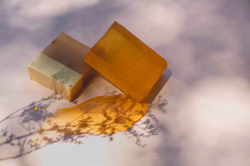 Close-up of handmade soap bars under artistic lighting, showcasing natural ingredients and shadows.
