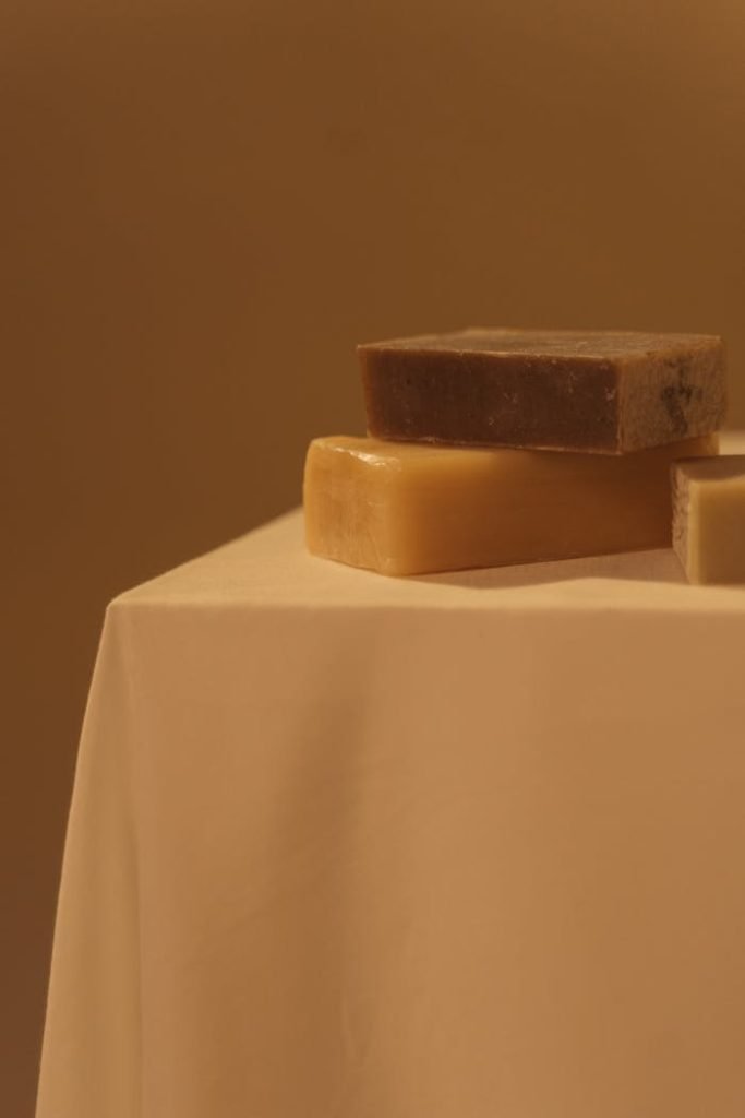 Warm-toned close-up shot of three natural soap bars on a table.